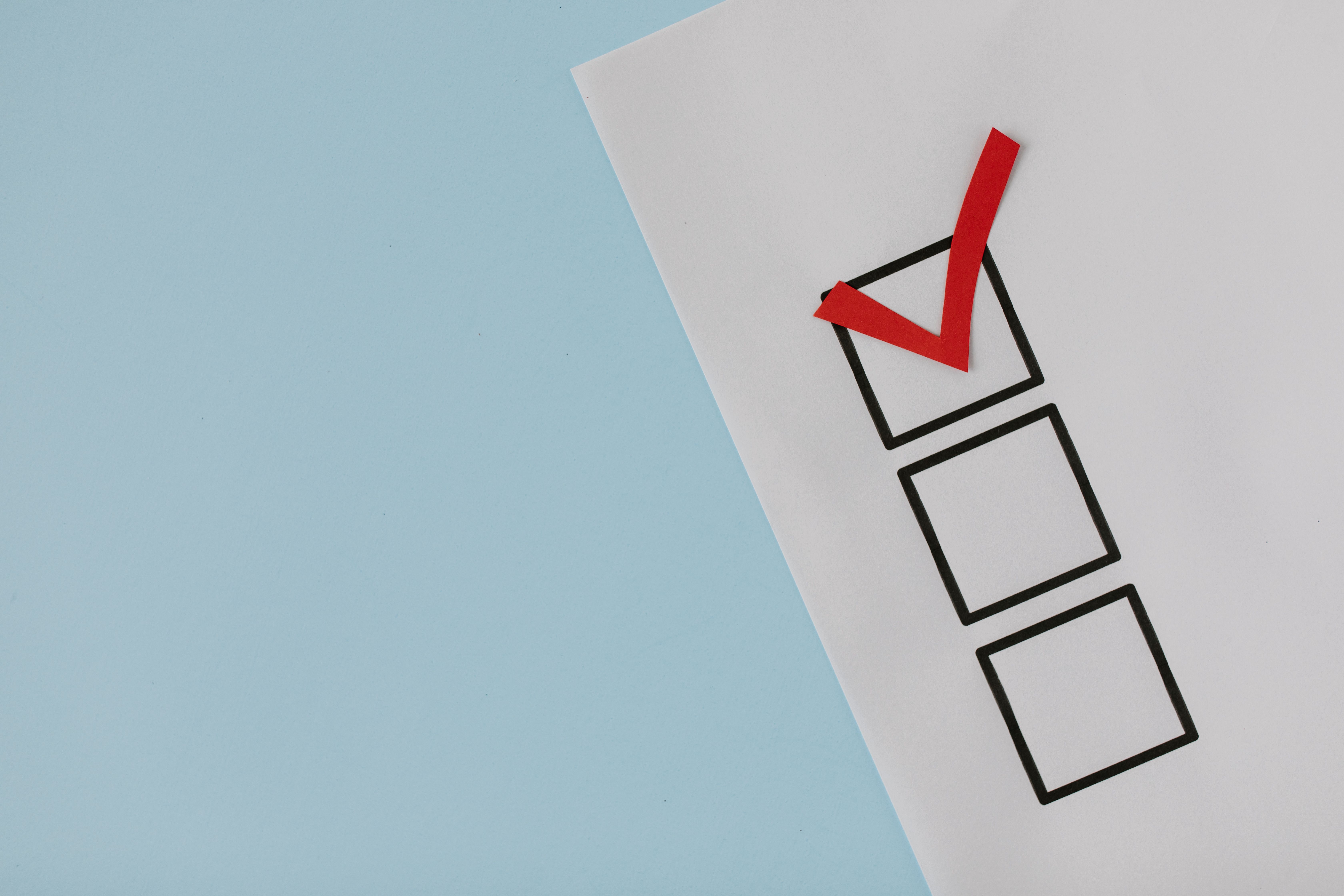 A simple white paper checklist with one red checkmark, ideal for concepts like completion or approval